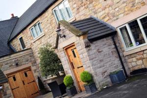 an old brick house with wooden doors on a street at The White Hart Inn in Alfreton