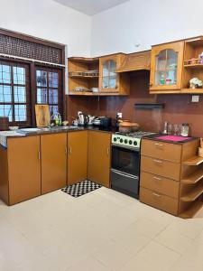 a kitchen with wooden cabinets and a stove at Himo Guest Inn in Dehiwala
