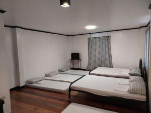 a room with three beds and a window at YANTO BEACH HAUS at CAGWAIT WHITE BEACH in Cagwait