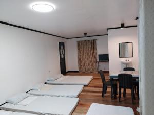 a room with four beds and a table and chairs at YANTO BEACH HAUS at CAGWAIT WHITE BEACH in Cagwait