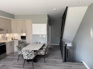 a kitchen and dining room with a table and chairs at Spacious New 3BR Townhome Walking to Falls in Niagara Falls +9 photos
