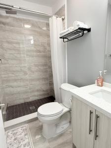 a white bathroom with a toilet and a shower at Spacious New 3BR Townhome Walking to Falls in Niagara Falls