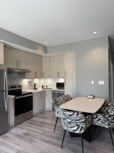 a kitchen with a table and chairs in it at Spacious New 3BR Townhome Walking to Falls in Niagara Falls