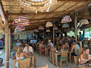 a group of people sitting at tables in a restaurant at Palm Beach Bungalow Resort in Koh Rong Island