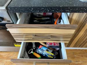 a drawer in a cabinet filled with tools at Cozy 2 BR Apartment with Easy Access in Ulaanbaatar