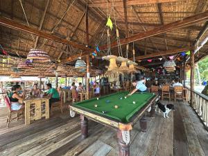 a man playing a game of pool in a restaurant at Palm Beach Bungalow Resort in Koh Rong Island
