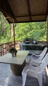 a white table and two white chairs on a patio at Pink Kangaroo Bungalows in Ko Kood