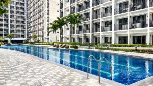 a swimming pool in front of a building at Cozy 619 1BR Shore2 Residence, Near Airport, IKEA, MOA, SMX, Pasay City, Manila in Manila