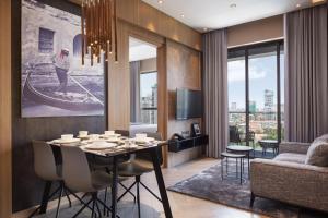 a dining room with a table with chairs and a couch at One Residence Hotel & Apartment in Phnom Penh