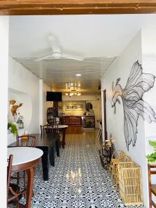 a dining room with tables and a bird mural on the wall at เชียงคานคลาสสิค in Chiang Khan