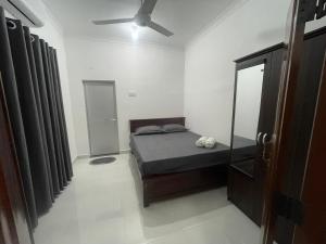 a bedroom with a bed and a ceiling fan at The Yarl Home in Jaffna