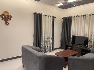 a living room with two couches and a tv at The Yarl Home in Jaffna