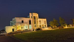 a large white building with a lot of windows at night at Raja Krishna Mahal in Kushinagar