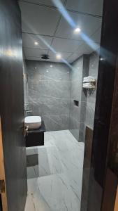 a bathroom with a shower with a sink and a toilet at Raja Krishna Mahal in Kushinagar