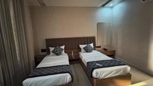 two beds in a small room with twoermott at Raja Krishna Mahal in Kushinagar +5 photos