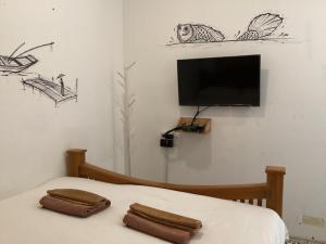 a bedroom with a bed with two brown towels on it at เชียงคานคลาสสิค in Chiang Khan