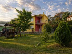 a yellow house with a playground in the yard at Cabañas equipadas en Vaqueros - naturaleza y tranquilidad cerca de Salta in Vaqueros