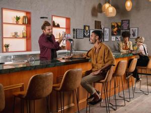 a man sitting at a bar with a bartender at JO&JOE Rio Largo do Boticario in Rio de Janeiro +99 photos