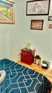 a bedroom with a bed and a dresser and a painting at Refuge Appartement in Montreal