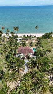 an aerial view of a resort on a beach with palm trees at Tha sala beach house in Ban Phang Pling
