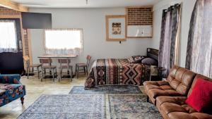 a living room with a couch and a bed and a table at Geraldton Rooms Unit D in Geraldton