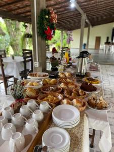 a table topped with plates and bowls of food at Pousada Ypê Amarelo in Itatiaia