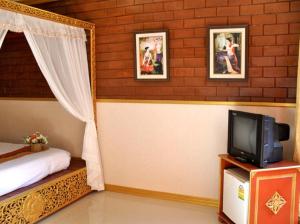 1 dormitorio con 1 cama y TV en una mesa en Irawadee Resort en Mae Sot