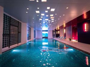 a large swimming pool in a hotel room with a pool at Mercure Tai'an Centre in Tai'an