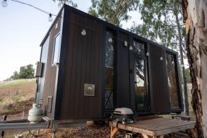 a black tiny house sitting on a picnic table at Pedlar Creek Tiny House by Tiny Away in McLaren Vale