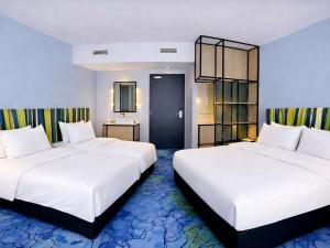 two beds in a hotel room with white sheets at IBIS STYLES MUENCHEN AIRPORT in Munich +60 photos