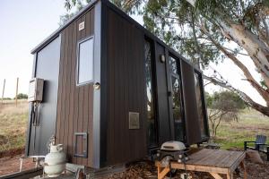 a black tiny house sitting on a picnic table at Pedlar Creek Tiny House by Tiny Away in McLaren Vale