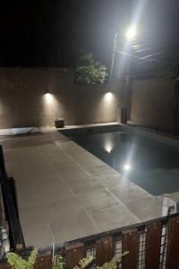 an empty swimming pool at night with lights at Nathaly aparts iguazú in Puerto Iguazú