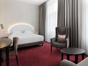 a hotel room with a bed and a chair at Hotel Rathauspark Wien - Handwritten Collection in Vienna +116 photos