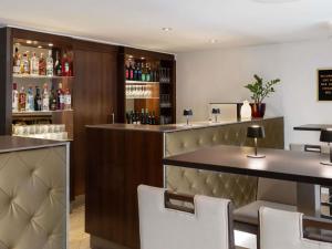 a bar in a restaurant with white chairs at Hotel Rathauspark Wien - Handwritten Collection in Vienna
