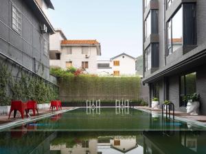 a courtyard with red chairs and a pool of water at Mercure Guilin Yangshuo Xingping in Guilin