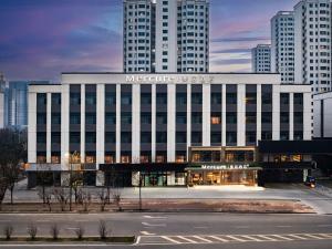 a large white building with a sign on it at Mercure Xi'an New Software City in Xi'an