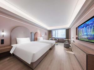 a hotel room with two beds and a flat screen tv at Mercure Xi'an New Software City in Xi'an