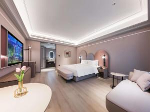a hotel room with a bed and a couch at Mercure Xi'an New Software City in Xi'an