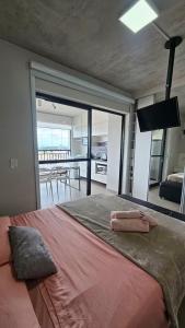 a bedroom with a large bed with a view of a kitchen at Studio Aurora, Bom Retiro - Anhembi - Com garagem in São Paulo +19 photos