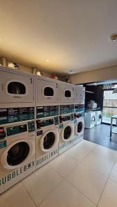 a laundry room with four washer and dryers at Studio Aurora, Bom Retiro - Anhembi - Com garagem in São Paulo