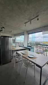 a kitchen with a table with chairs and a refrigerator at Studio Aurora, Bom Retiro - Anhembi - Com garagem in São Paulo