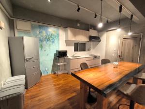 a kitchen with a wooden table and a refrigerator at Shiraho Breeze Poolside Villa in Ishigaki Island +19 photos