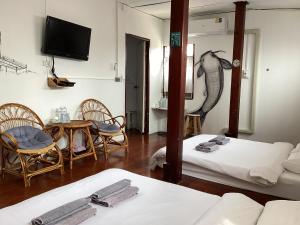 a room with two beds and a table with a dolphin on the wall at เชียงคานคลาสสิค in Chiang Khan