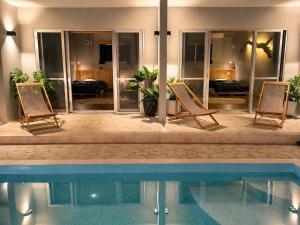 two chairs and a swimming pool in a house at Shiraho Breeze Poolside Villa in Ishigaki Island
