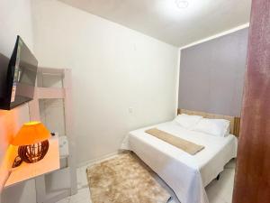 a small bedroom with a bed and a television at Refugio tropical icarai in Icaraí