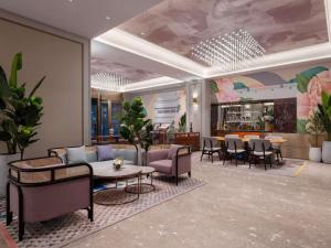 a lobby with a waiting area with tables and chairs at Mercure Pingyao Ancient City in Pingyao