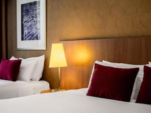 a hotel room with two beds with red pillows at Mercure Sydney St Leonards in Sydney +73 photos