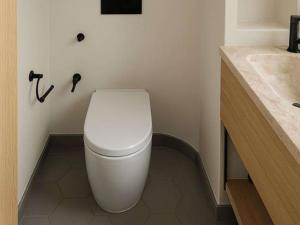 a bathroom with a white toilet and a sink at Caravan Hatta by Our Habitas in Hatta
