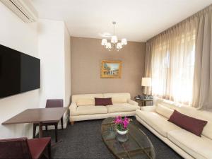a living room with a couch and a table at Adabco Boutique Hotel Adelaide in Adelaide