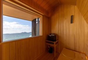 a room with a window and a small television at Sunset SPA Resort AJI by SETO CLAS in Takamatsu